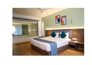 罗纳瓦拉Ikshana Resort and Spa, Khandala的有一张大床和一扇窗户的酒店房间
