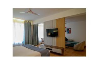 罗纳瓦拉Ikshana Resort and Spa, Khandala的一间配有床和平板电视的酒店房间