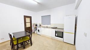 SKY Way City Apartment, 150m from Chabad Lubavitch في لارنكا: مطبخ مع طاولة وثلاجة