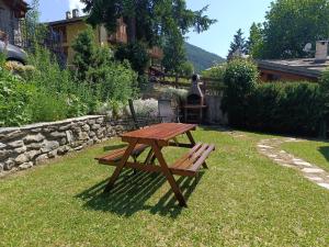 a wooden picnic table sitting in the grass at Sauze d'Oulx ciabot la garitüla with garden - wifi- close to the chairlift in Sauze dʼOulx