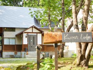 a home with a sign in front of a house at Kudo's Lodge in Hakuba