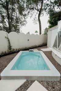 a swimming pool in a backyard with a white fence at Kaung Cabins in Cibogo