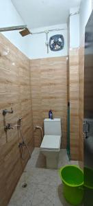 a bathroom with a toilet and a green tub at Namo Homestay in Guwahati