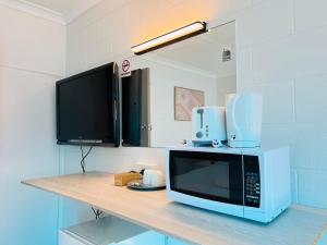 a microwave sitting on top of a table with a tv at Motel Maroondah in Box Hill +45 photos