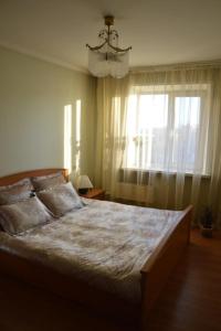 a bedroom with a large bed and a window at Apartment NG Na Chertygasheva in Abakan