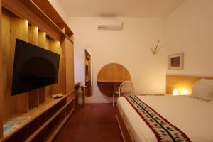 a hotel room with a bed and a flat screen tv at Hotel Ayook in Oaxaca City