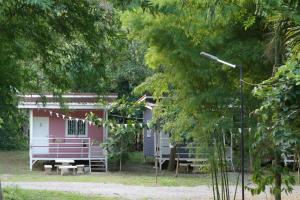 a pink and white cabin in the woods at NP โฮมสเตย์ นอนเต็นท์ติดแอร์ in Ban Kaeng Manao
