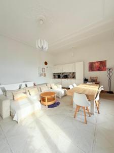 un soggiorno con mobili bianchi e tavolo di Duplex 10P Jacuzzi Terrasse Vue Mer et Montagne Marseille a Marsiglia