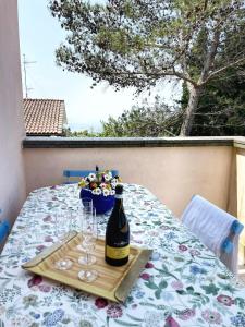 Una botella de vino sobre una mesa con copas. en Villa Simonetta, en Castellina Marittima