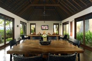 a dining room with a large wooden table and chairs at Qunci Villas Resort in Senggigi