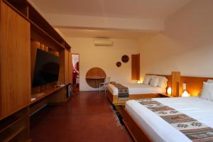 a hotel room with two beds and a flat screen tv at Hotel Ayook in Oaxaca City