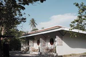a white house with chairs in front of it at NP โฮมสเตย์ นอนเต็นท์ติดแอร์ in Ban Kaeng Manao