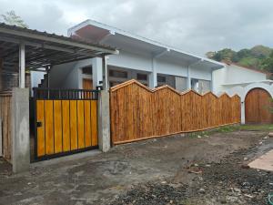 una casa con una puerta de madera y una valla en Cherry Homestay, en Kuta Lombok
