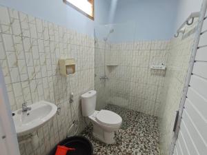 un baño con inodoro y lavabo en Cherry Homestay, en Kuta Lombok