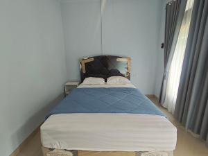 Un dormitorio pequeño con una cama en una habitación. en Cherry Homestay, en Kuta Lombok