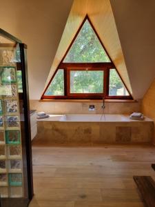 a bathroom with a large window and a bath tub at L'atelier in La Rochefoulques +33 photos