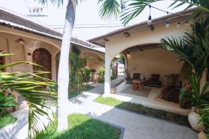 an outside view of a house with palm trees at Amani Boutique Stay in Gili Trawangan