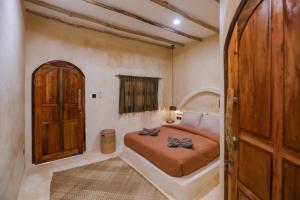 a bedroom with a bed and a wooden door at Amani Boutique Stay in Gili Trawangan