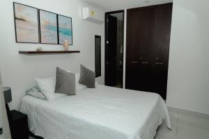 a bedroom with a white bed with two pillows at Hermoso apartamento. Cerca del mar. in Santa Marta +33 photos