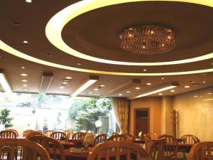 une salle à manger avec un lustre, des tables et des chaises dans l'établissement Seoul Rex Hotel, à Séoul