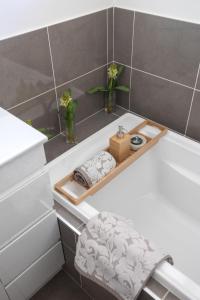 a bathroom with a white bath tub with a wooden tray at Still Water on Aney in Manyana