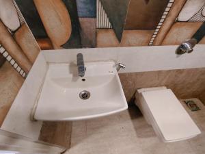 a bathroom with a sink and a toilet at Hotel Harmony heights in Pune +16 photos