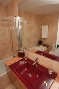 W łazience znajduje się czerwona umywalka i prysznic. w obiekcie Quinta da Veiga w mieście Covas do Douro