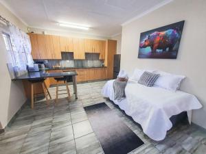 a bedroom with a bed and a table and a kitchen at Hippo's Rest in Ellisras