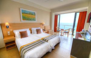 een hotelkamer met een groot bed en een balkon bij The Preluna Hotel in Sliema