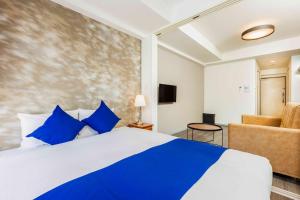 a bedroom with a blue and white bed and a chair at FDS Plaisir in Osaka