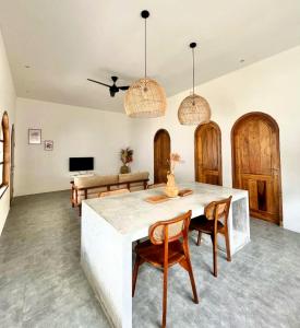 a living room with a table and chairs and a couch at VILLA LULU 1- 2 bedrooms villa - private pool in Kuta Lombok