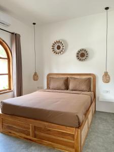 a bed in a bedroom with two mirrors on the wall at VILLA LULU 1- 2 bedrooms villa - private pool in Kuta Lombok