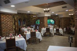 a restaurant with white tables and chairs and brick walls at Hotel Livia in Ksamil
