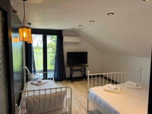 a bedroom with two twin beds and a television at Daskalis House # Даскаловата Къща in Alexandroupoli