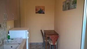 a small kitchen with a table and a refrigerator at Apartments Palladium in Olympiaki Akti