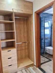 La salle de bains est pourvue d'un placard en bois et d'une porte en verre. dans l'établissement Charming Twin House In Paros - Mountain View Ras ElHikma - North Coast Egypt, à Ras Elhekma