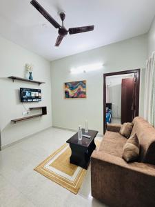 a living room with a couch and a ceiling fan at Penthouse Escape 1BHK Park View Flat in Kondapur in Hyderabad