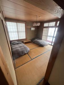 two beds in a room with windows at Full 7 bedroom house Nozawa Onsen in Iiyama +7 photos