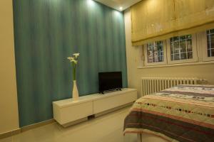 Apartments Jevremova في بلغراد: غرفة نوم بها سرير و مزهرية بها زهور