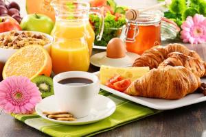 a breakfast table with a plate of food and a cup of coffee at La Balinaise in Hourtin