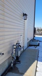 a water pump on the side of a building at Newly Built Private Basement Suite in Prescott in Spruce Grove
