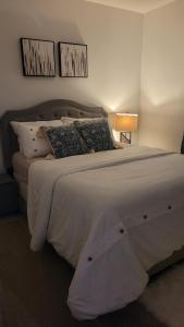 a bedroom with a large white bed with pillows at Newly Built Private Basement Suite in Prescott in Spruce Grove