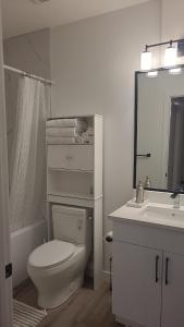 a bathroom with a toilet and a sink and a mirror at Newly Built Private Basement Suite in Prescott in Spruce Grove +16 photos