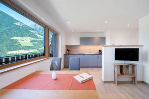Una cocina y un salón con un gran ventanal. en Tholerhof, en Scena
