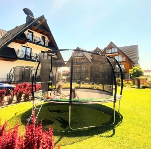 two girls playing in a trampoline in a yard at GÓRALSKIE NOWE APARTAMENTY BIAŁKA - Basen z podgrzewaną wodą, Sauny, Bania, Sale Zabaw - w cenie in Białka Tatrzańska