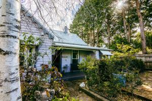 a white house with a porch in a yard at Chinoiserie - Blue Mountains Boho Luxe in Katoomba