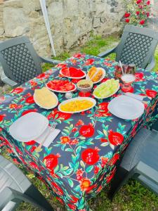 a picnic table with plates of food on it at Cozy-Corner Guesthouse in Mestia