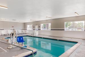 a swimming pool with a blue chair in a building at Quality Inn & Suites Denver Airport - Gateway Park in Aurora