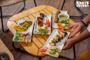 ein Tisch mit mehreren Tellern mit Essen darauf in der Unterkunft StayVista at Alpine Bliss - Home Theatre, Bonfire in Masuri