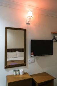 a room with a mirror and a tv on a wall at Impress Star Hotel in Kampong Saleng +13 photos